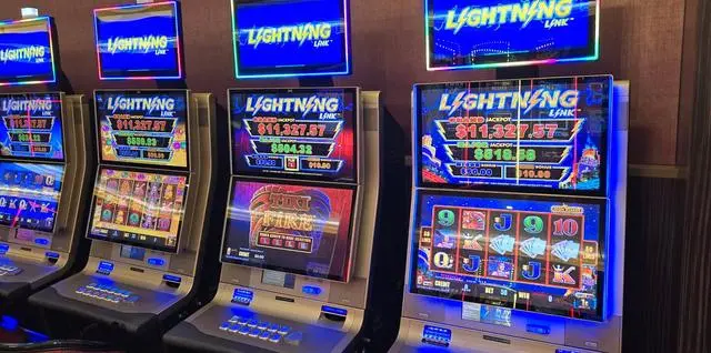 Four Lightning Link slot machines side by side, each topped with a blue Lightning Link sign, all displaying the same Grand jackpot of $11,327.57 but different Major jackpot values.