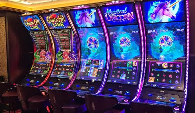 Quick Hit Link and Quick Hit Link Gems cabinets beside three Mystical Unicorn Wheel machines with purple unicorn artwork and a bonus wheel on each upper screen.