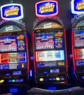Spitfire Multipliers titles above three Celebrity Apex slot cabinets